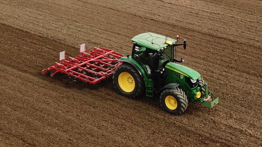 Traktor mit Grubber am Feld